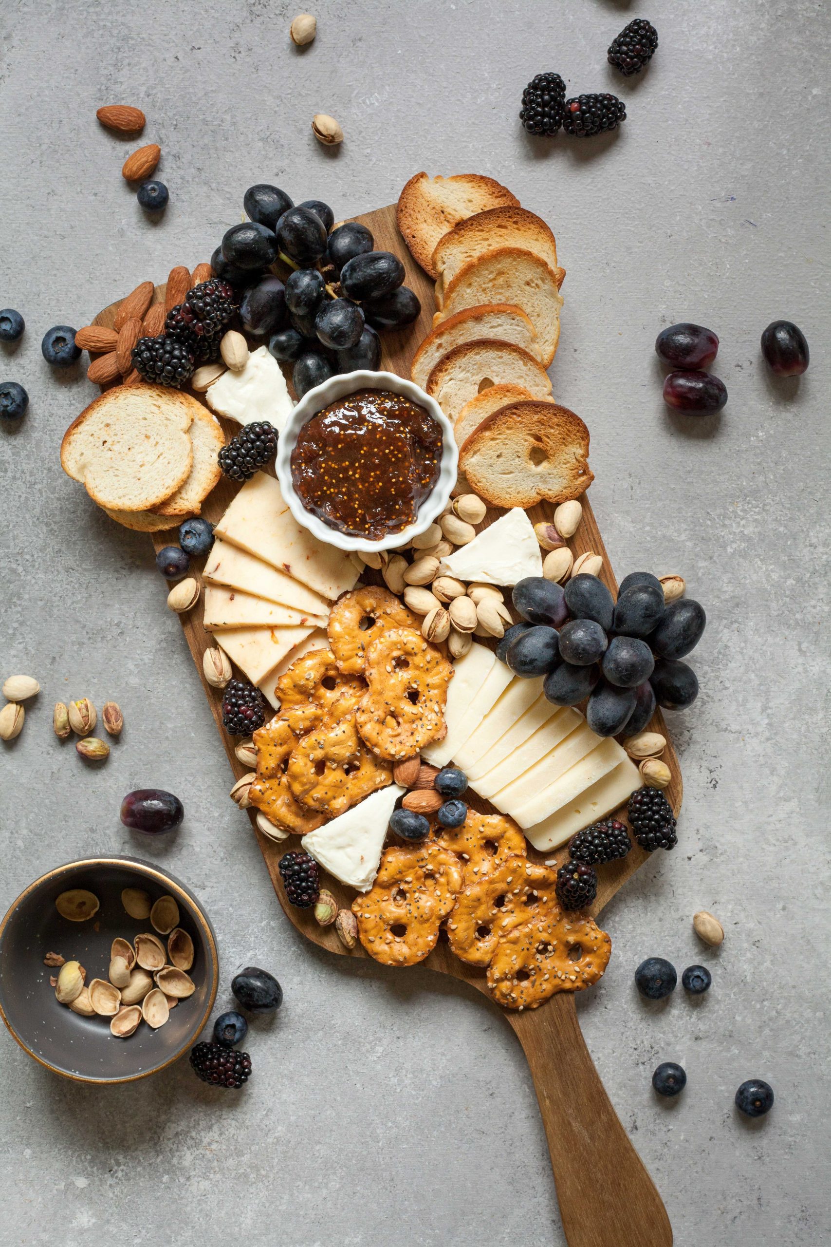 Charcuterie board with cheese, crackers, fruits and nuts arranged for entertaining or gourmet gifting.