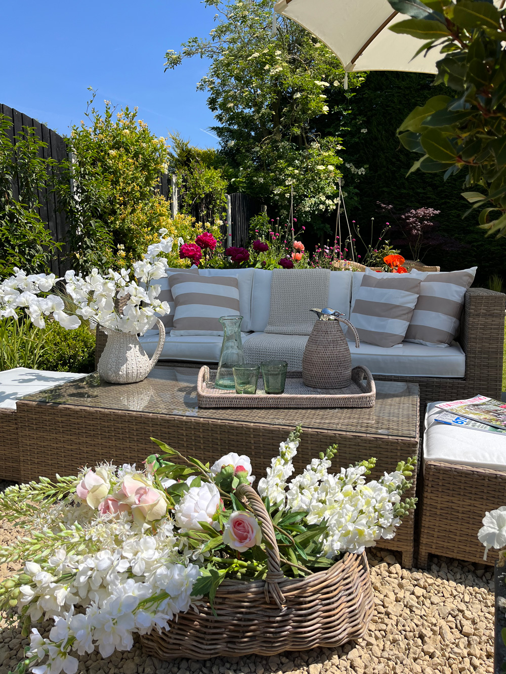 a stunning garden in the sunshine with a basket full of fresh flowers for mothers day