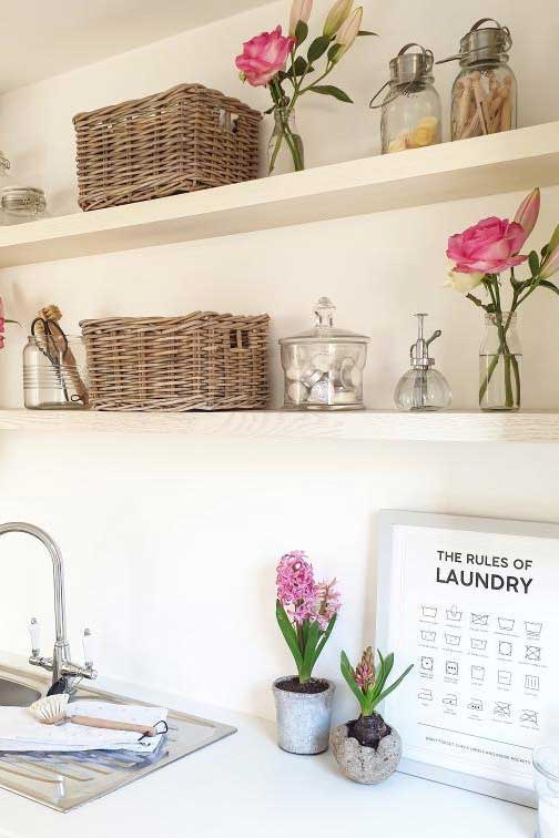 a clean and organised utility room with wicker baskets