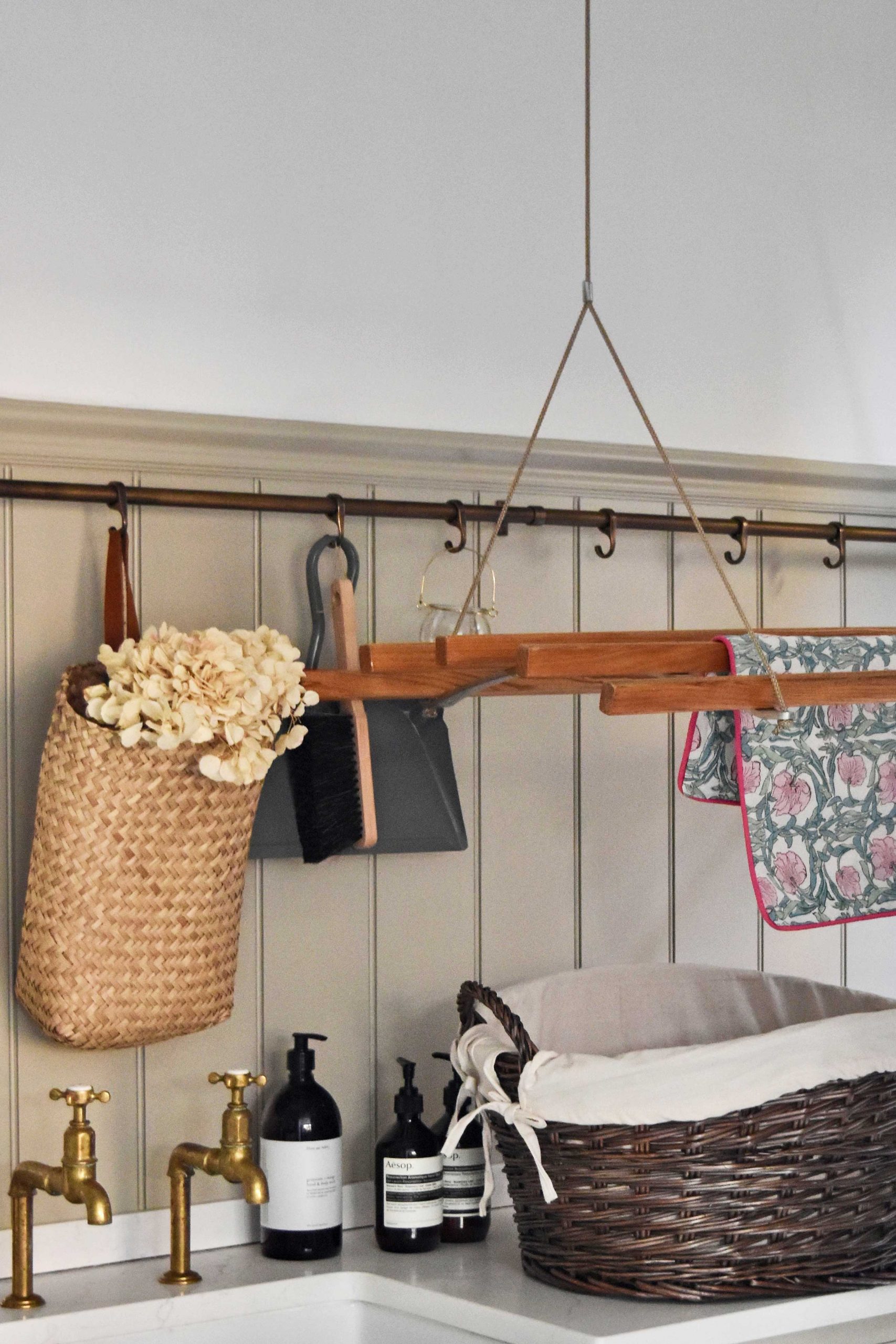 An antique wash wicker washing basket styled in a rustic utility room