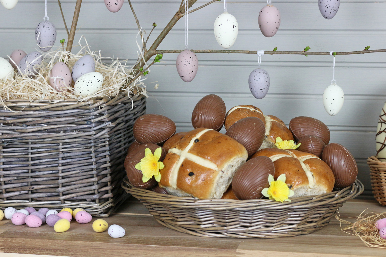 A wicker easter hamper tray full of hot cross buns.