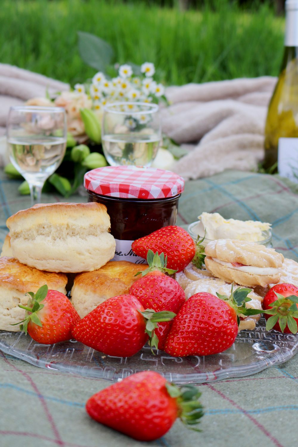 A cream tea selection in a picnic hamper including strawberries, scones, jam and cream