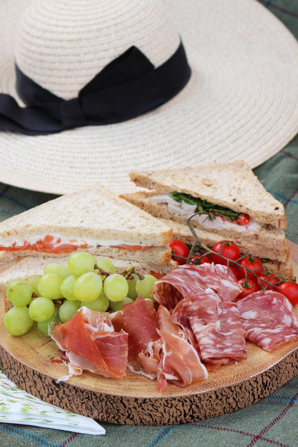 Picnic sandwiches, cured meats and grapes selection ready for alfresco dining.