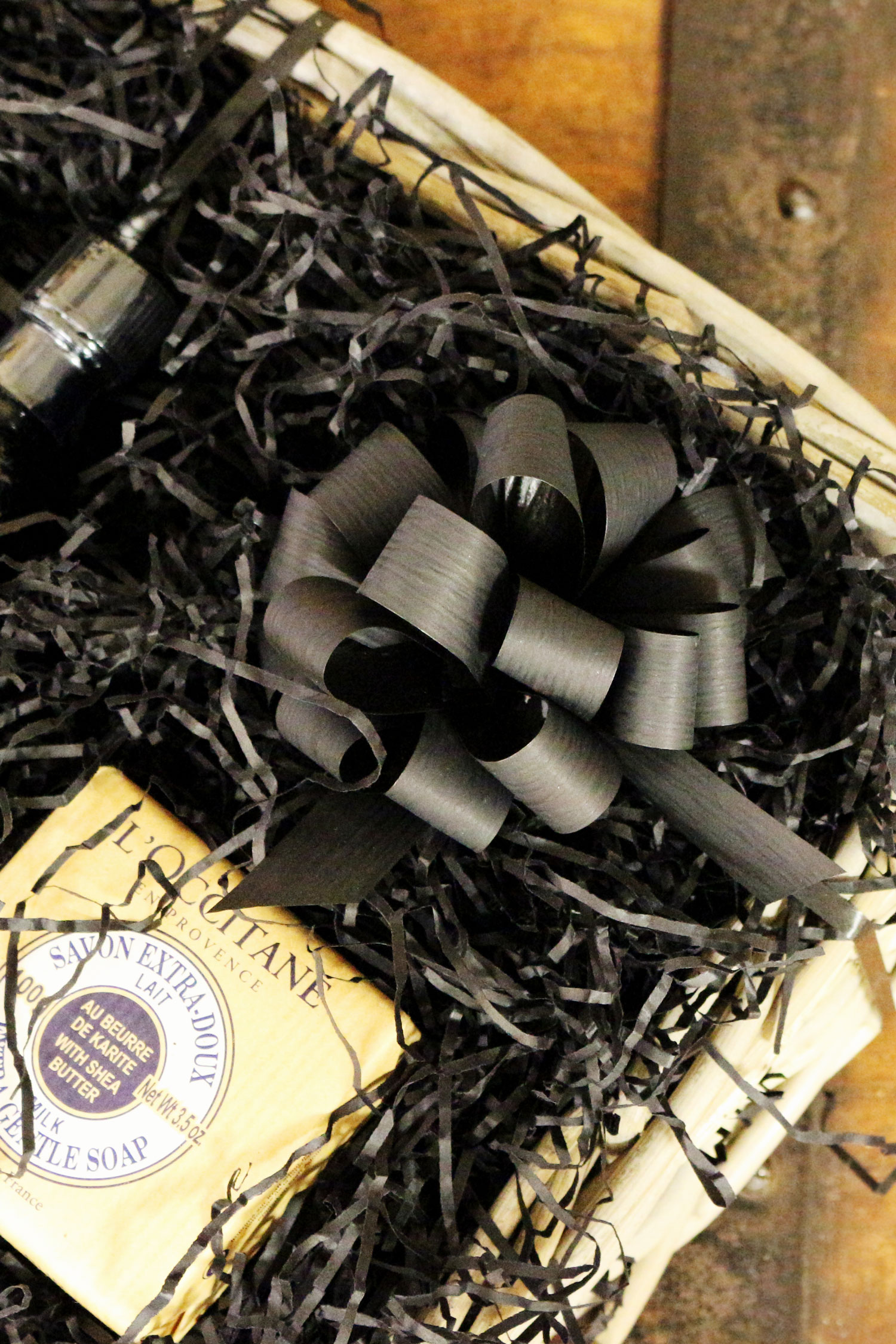 A black raffia gift bow attached to a Father's Day gift hamper