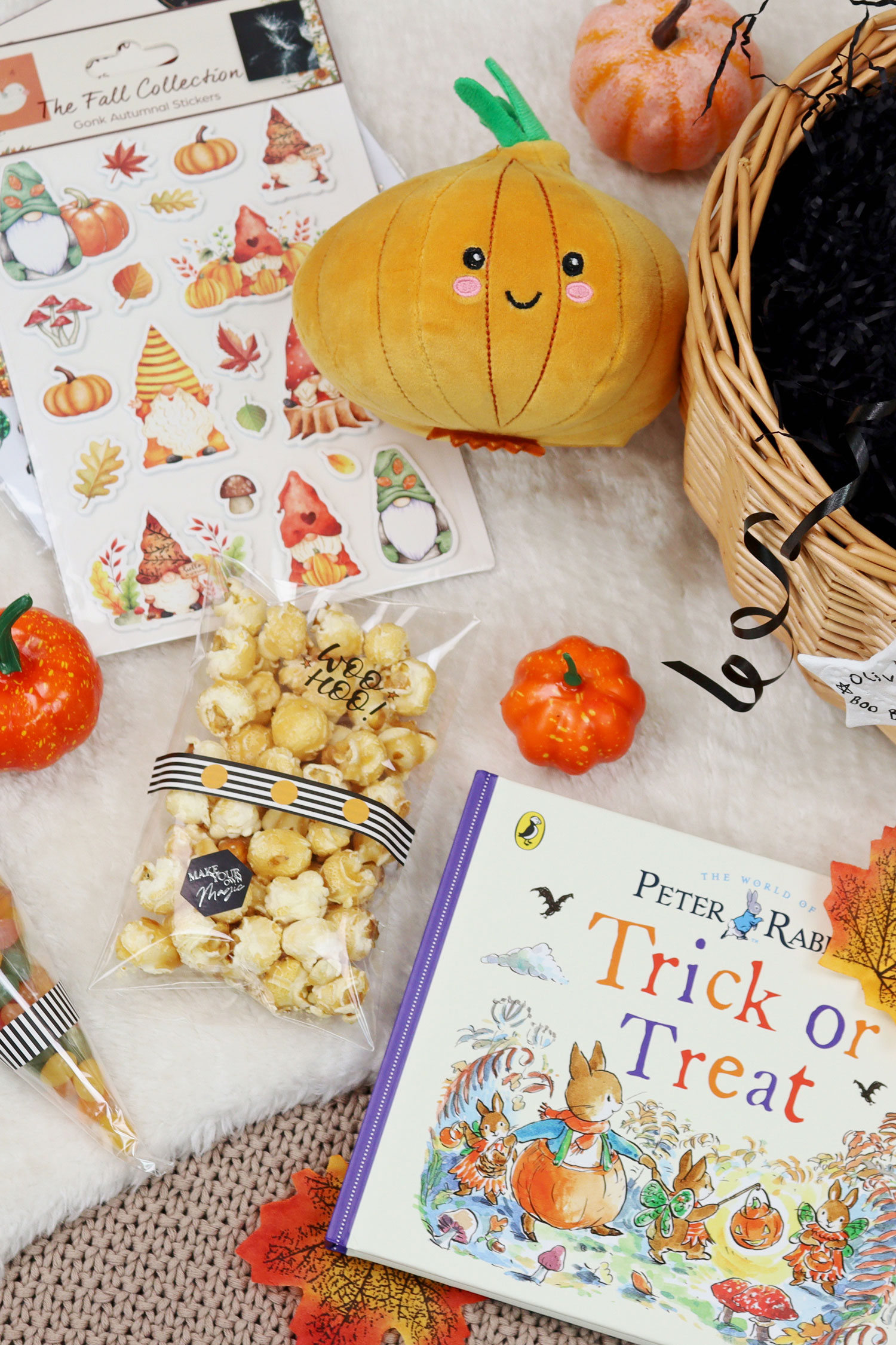 Autumn themed Boo Basket contents including a pumpkin toy, mini decorative pumpkins, Halloween stickers, caramel popcorn and a Peter Rabbit Trick or Treat book.