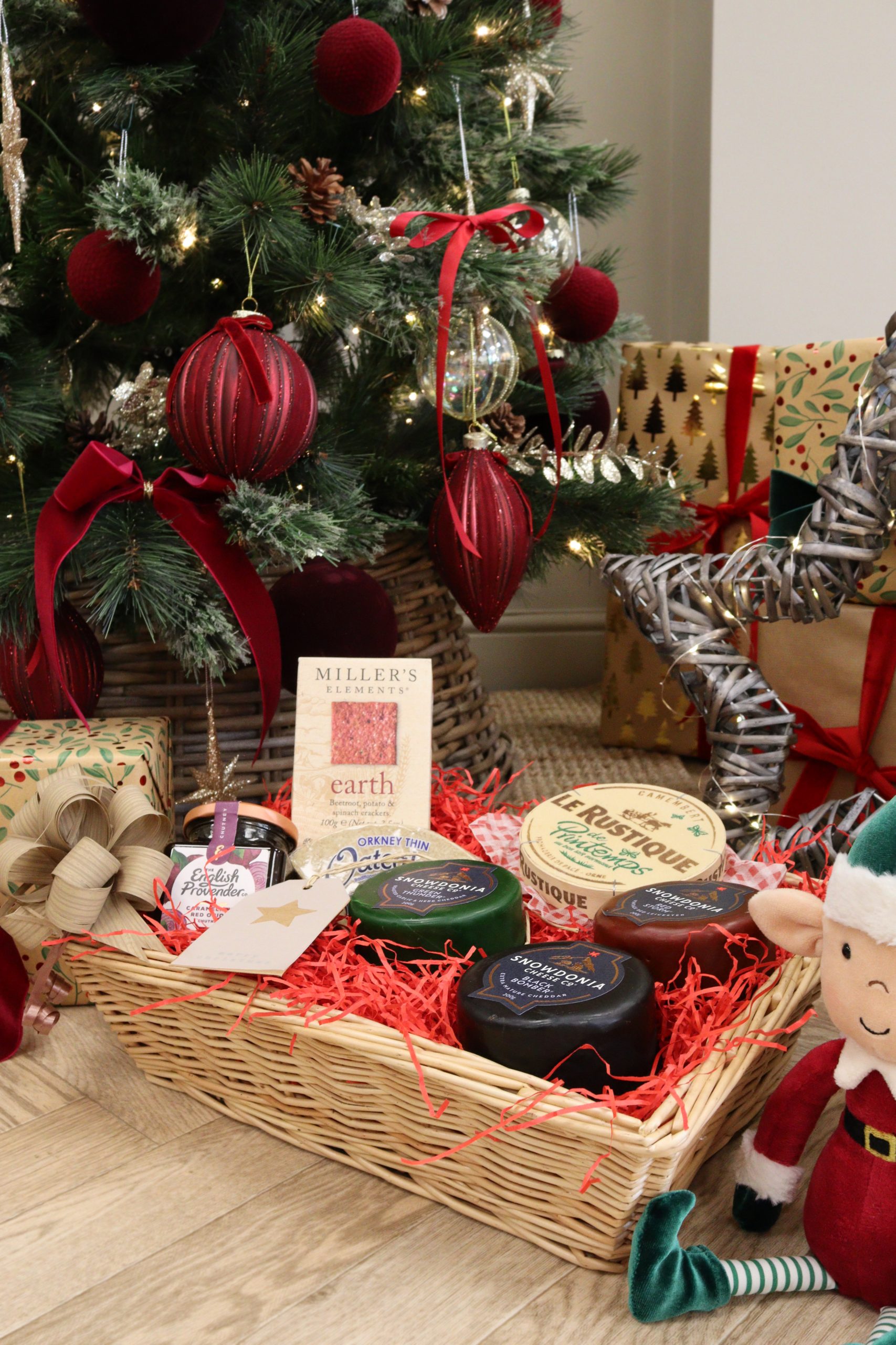 Festive cheese gift hamper under the tree with artisan chutney, crispbreads, and gourmet cheese truckles.