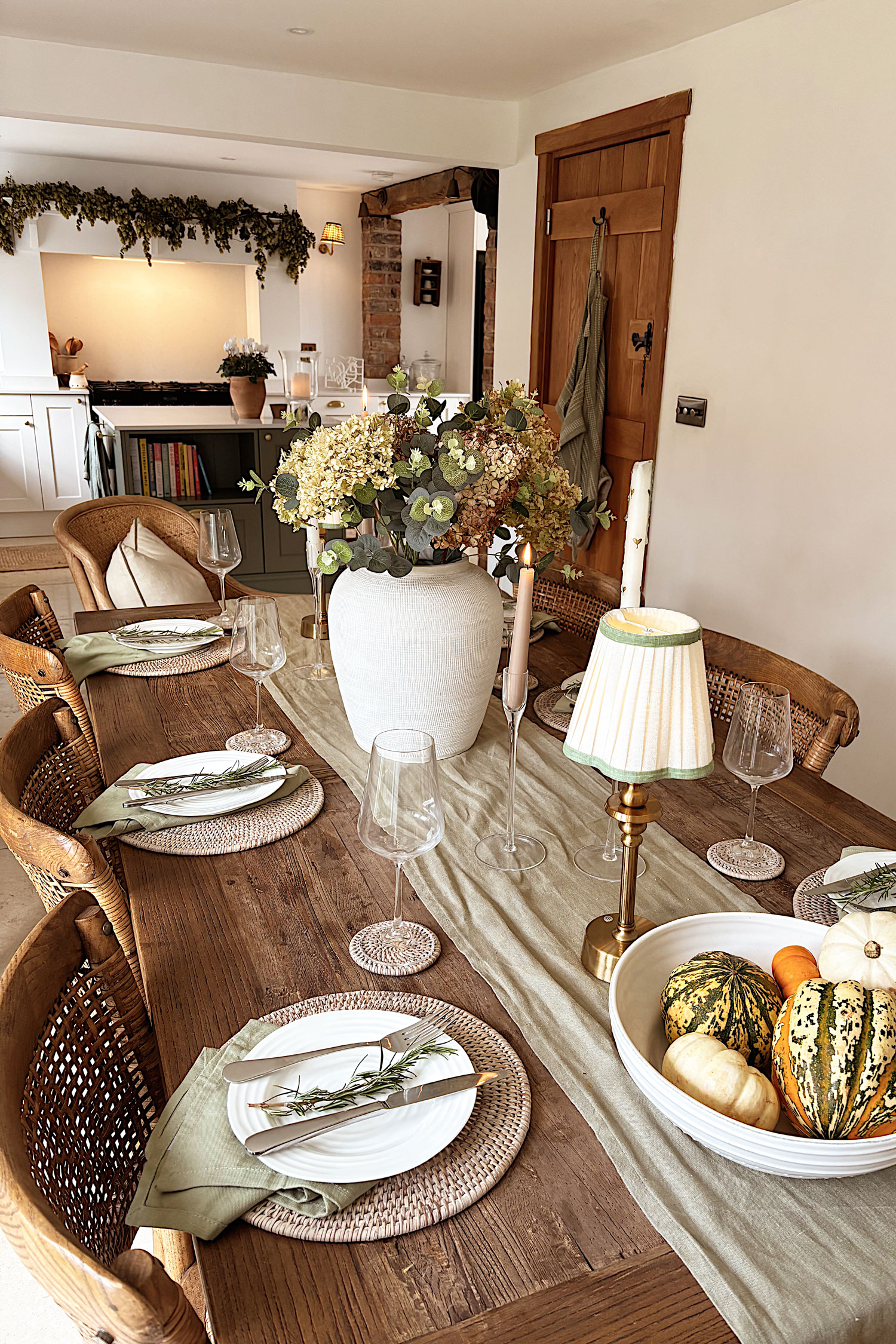 Rustic dining table styled with neutral linens, rattan tableware, and a central floral arrangement for a warm, seasonal tablescape.