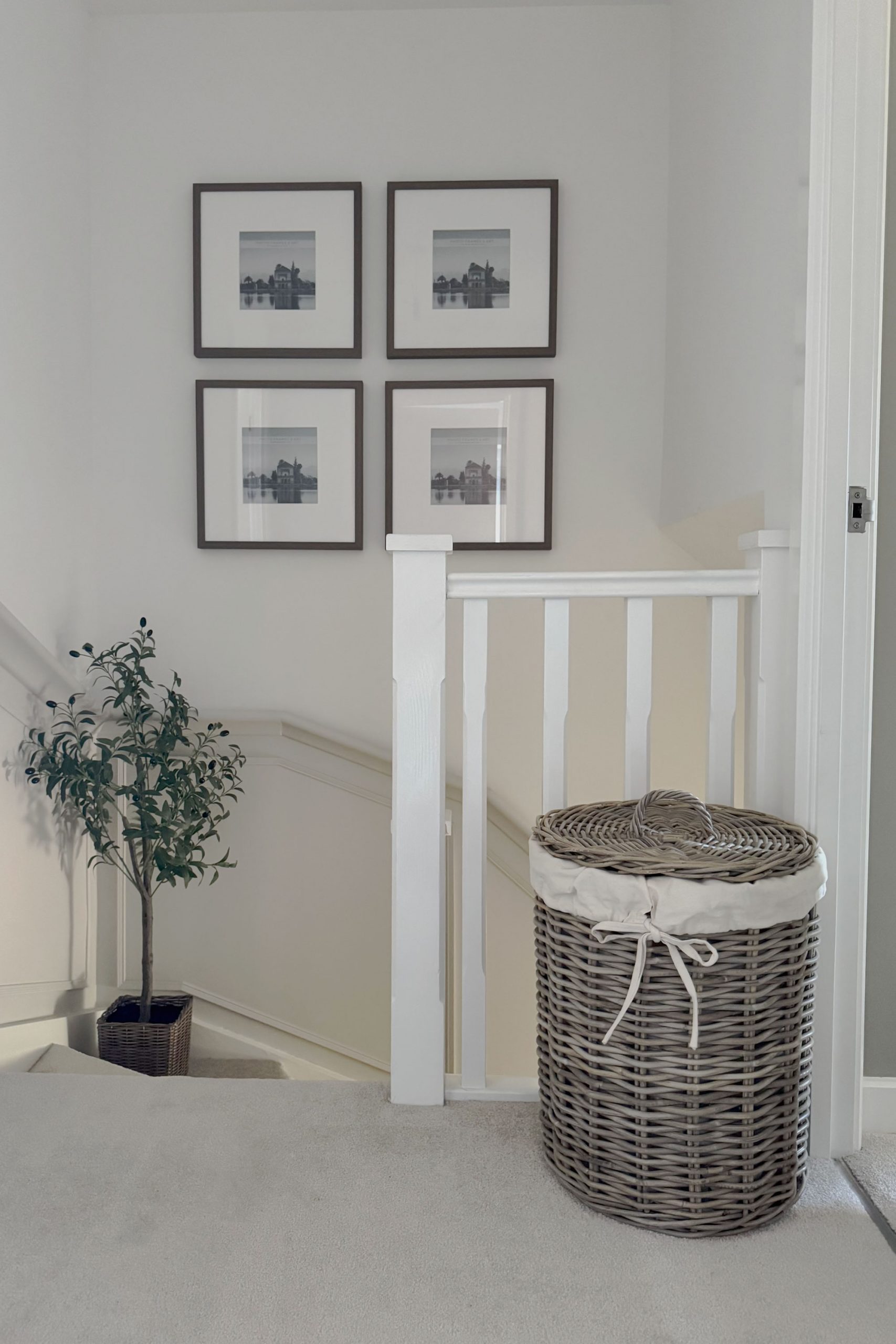 Rattan laundry basket with fabric liner on a staircase landing, offering discreet and stylish laundry storage for upstairs spaces.