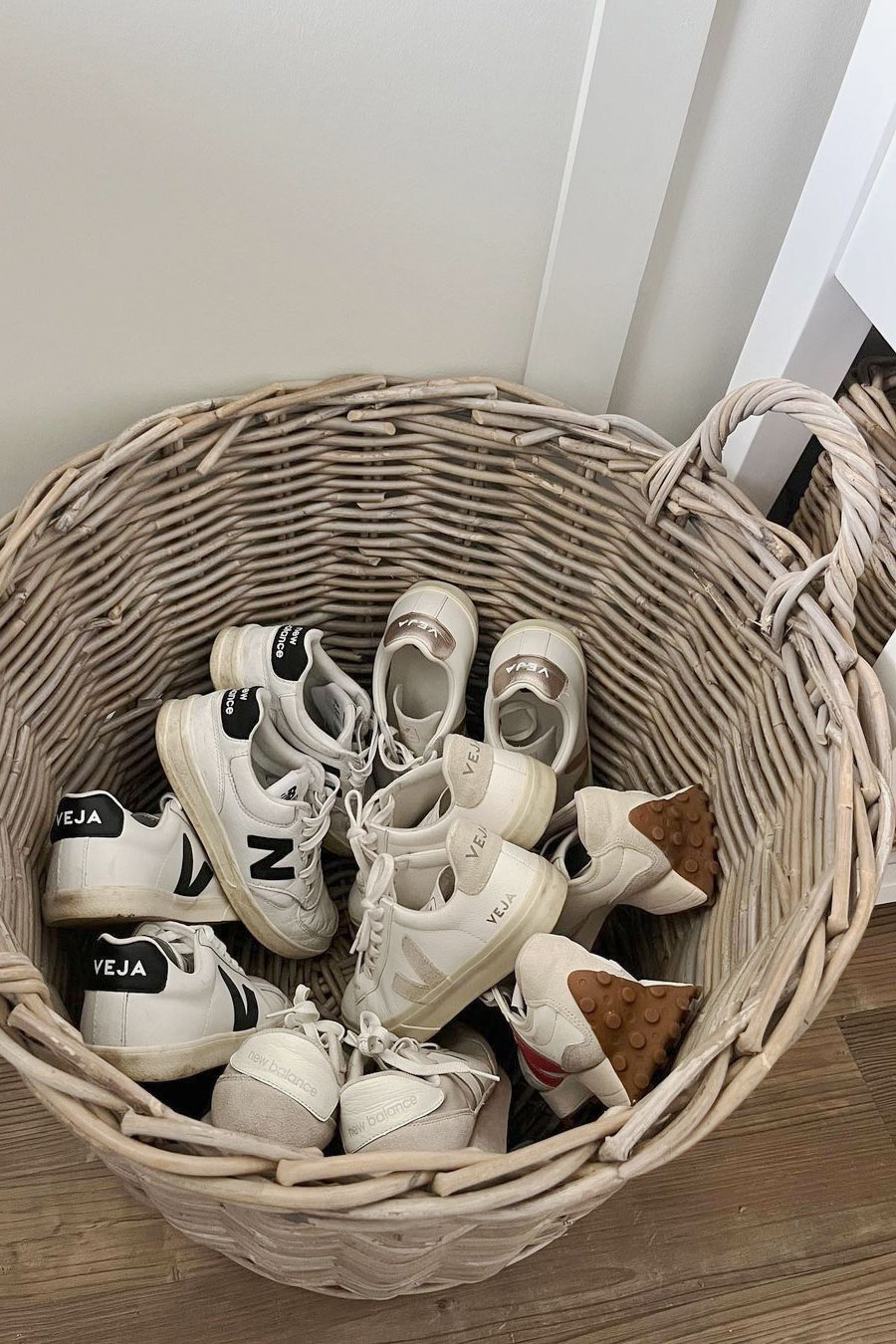 Large rattan shoe basket filled with trainers, offering stylish and practical shoe storage for hallways or bedrooms.